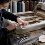 Formation ameublement decoration CAP tapisserie en atelier, tapisseuse recouvrant un fauteuil